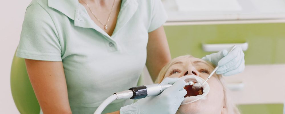 Senior woman having dental treatment at dentist's office. Woman is being treated for teeth